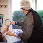 Hofbauer Periodontist hygienist performing cleaning and patient care