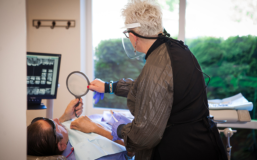 Hofbauer Periodontist hygienist performing cleaning and patient care